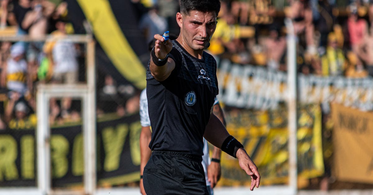 Soccer referee signaling a decision during an intense game outdoors.